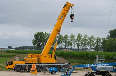 pexels photo 33488898 33488898 A large yellow crane at a construction site with lush greenery in the background.